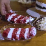 A hand reaches for a slice of cake on a party table