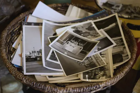 A wicker basket full of old black and white snapshots